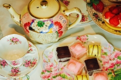 Teapot and teacups with cakes